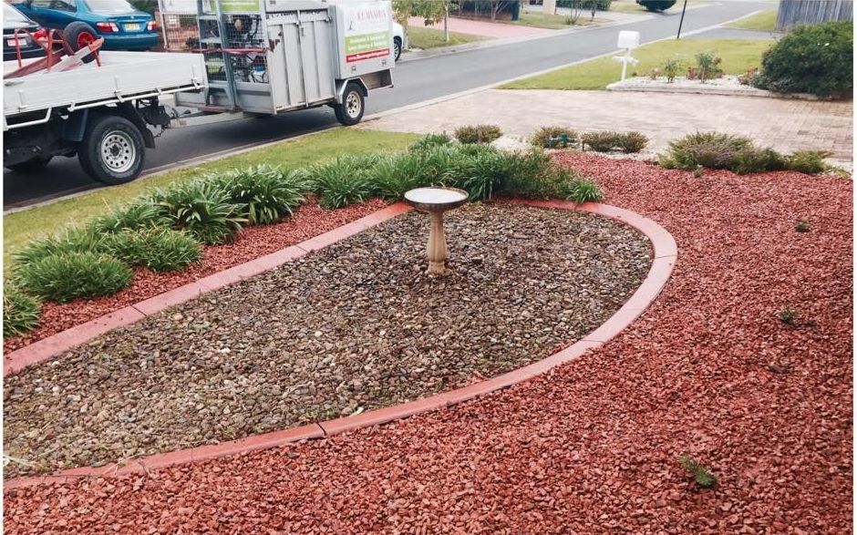 A White Truck is Parked in Front of a Garden With a Bird Bath — Illawarra Gardening Landscapes in Wollongong, NSW