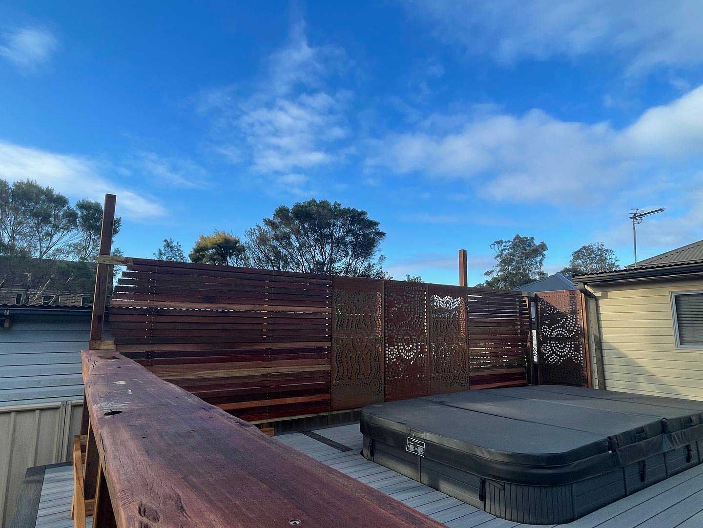 A Hot Tub is Sitting on Top of a Wooden Deck — Illawarra Gardening Landscapes in Blackbutt, NSW