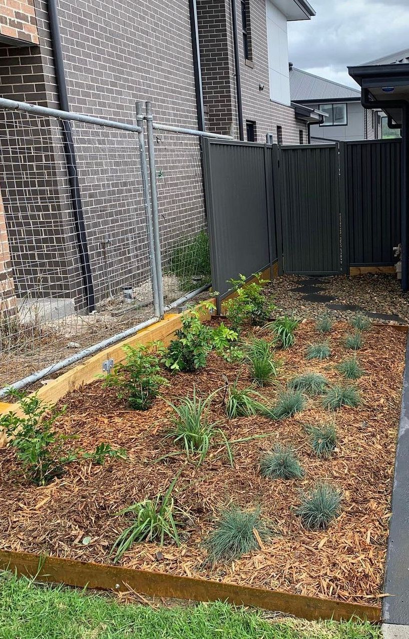 A Garden With a Fence and a Brick Building — Illawarra Gardening Landscapes in Southern Highlands, NSW