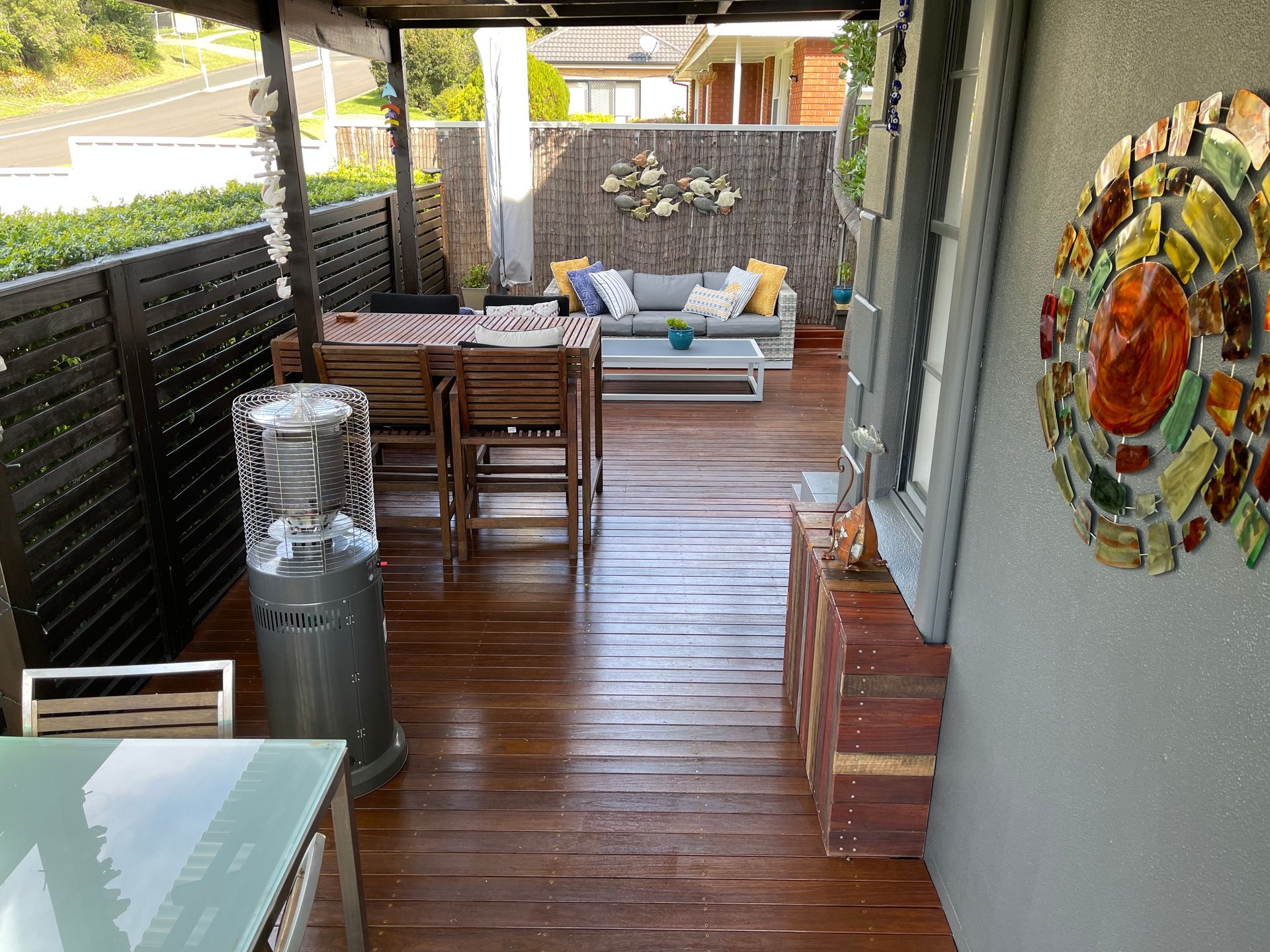 A Wooden Deck With a Table and Chairs and a Couch — Illawarra Gardening Landscapes in Wollongong, NSW