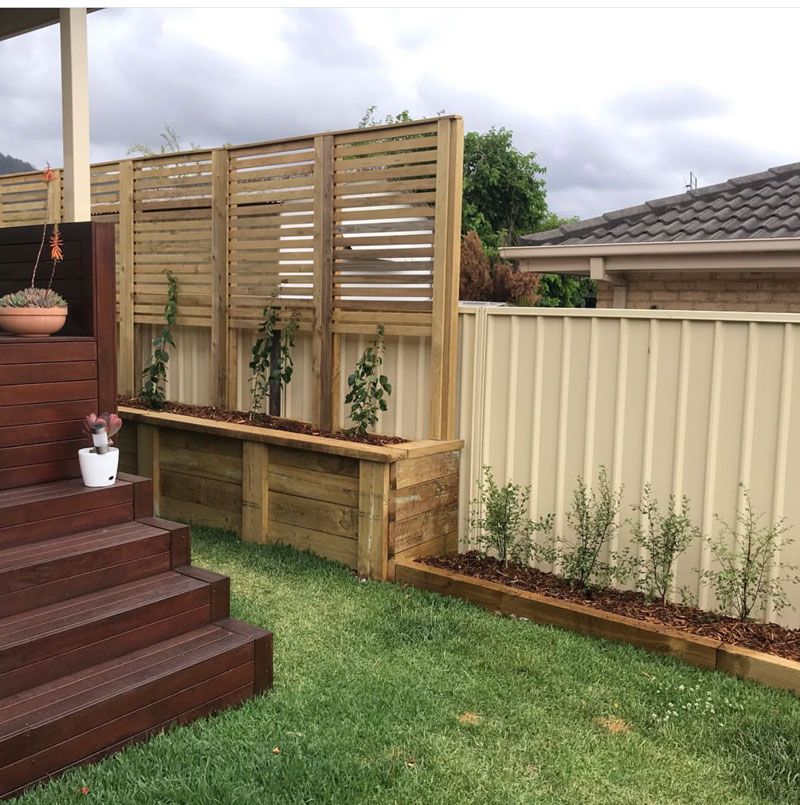 A Backyard With a Wooden Fence, Planters and Steps — Illawarra Gardening Landscapes in Blackbutt, NSW
