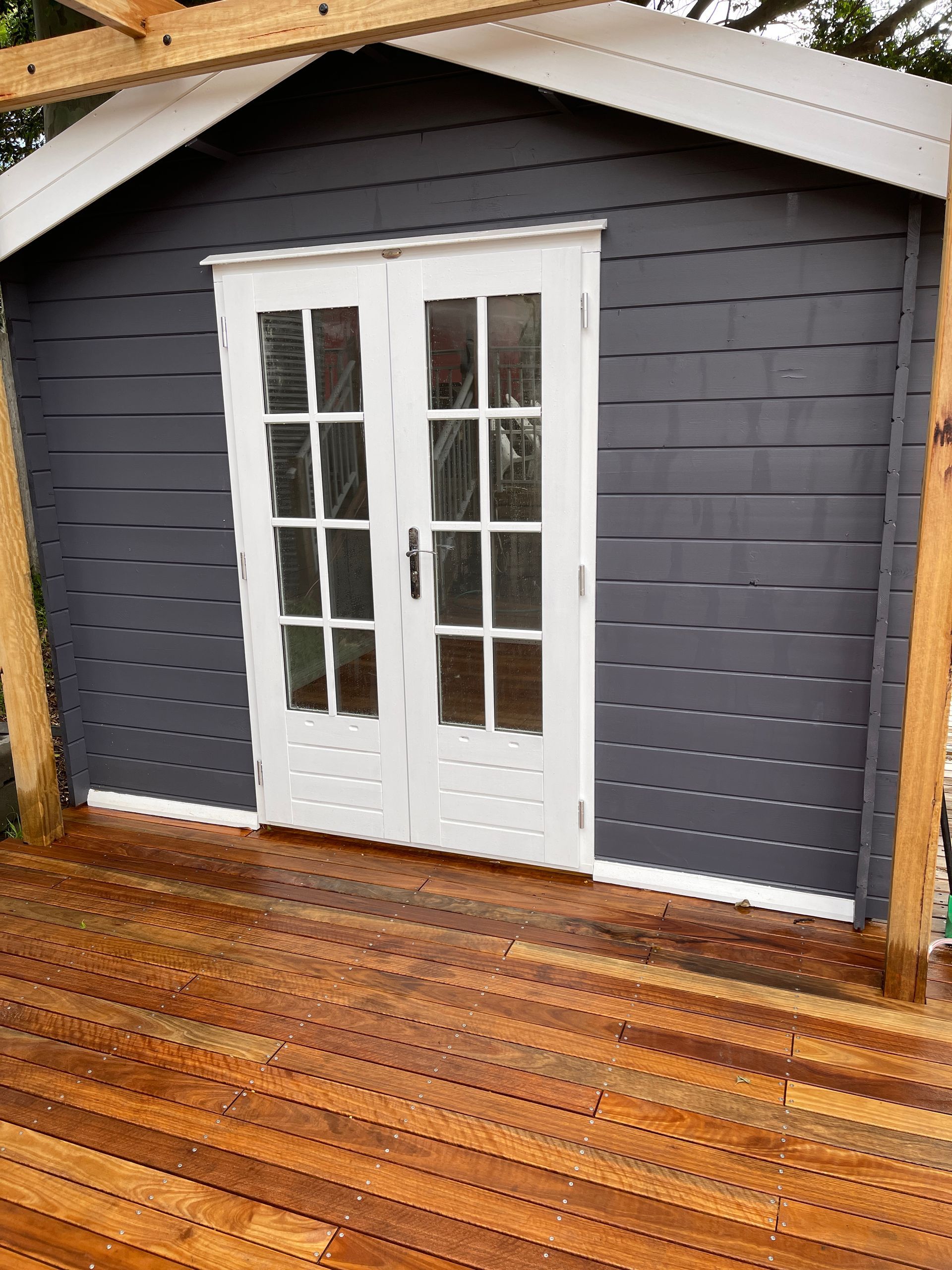 A Shed With French Doors and a Wooden Deck — Illawarra Gardening Landscapes in Blackbutt, NSW