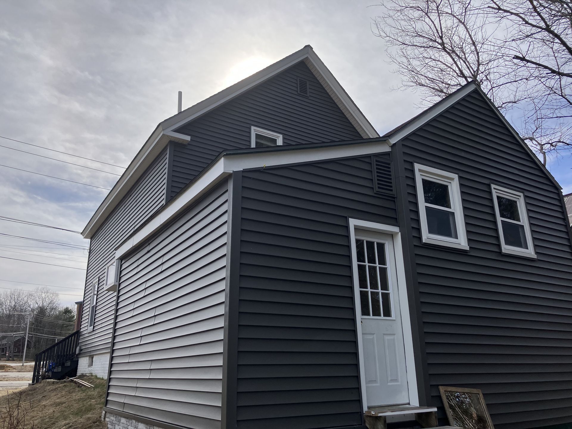 A blue house with white trim and shutters on the windows