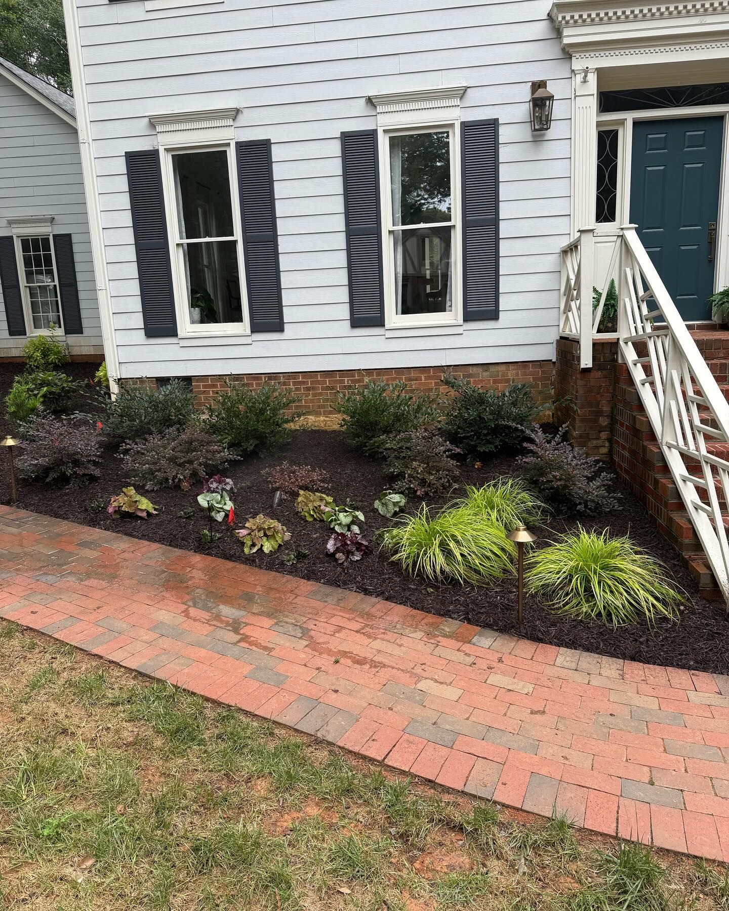 A house with blue siding and a brick walkway