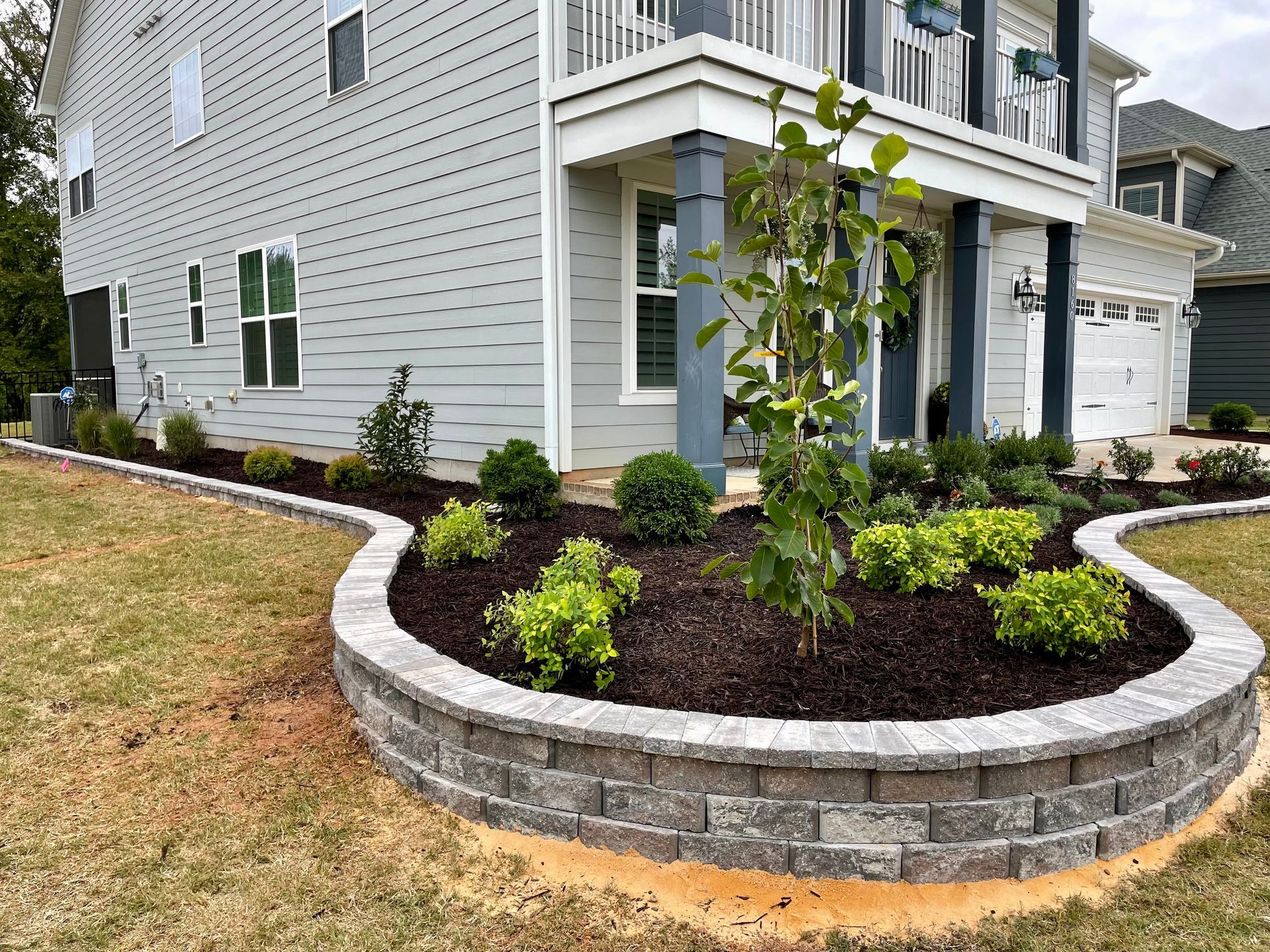 Modern office buildings with a walkway between them, landscaped courtyard, sunny day.