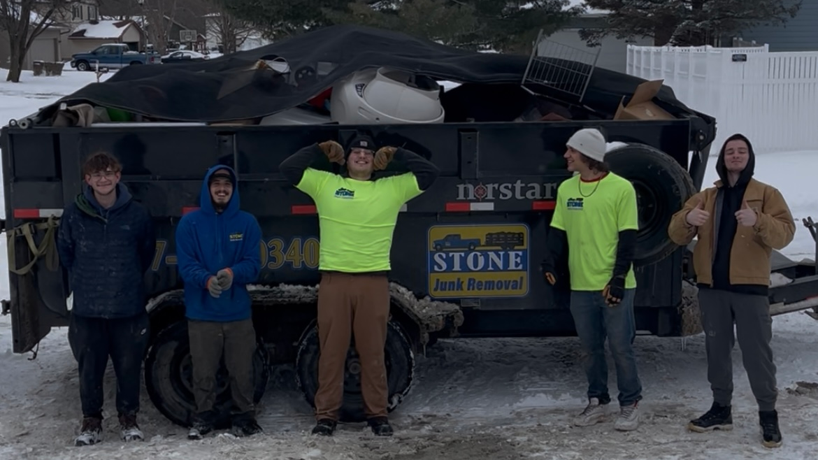 A group of people standing in front of a truck that says stone