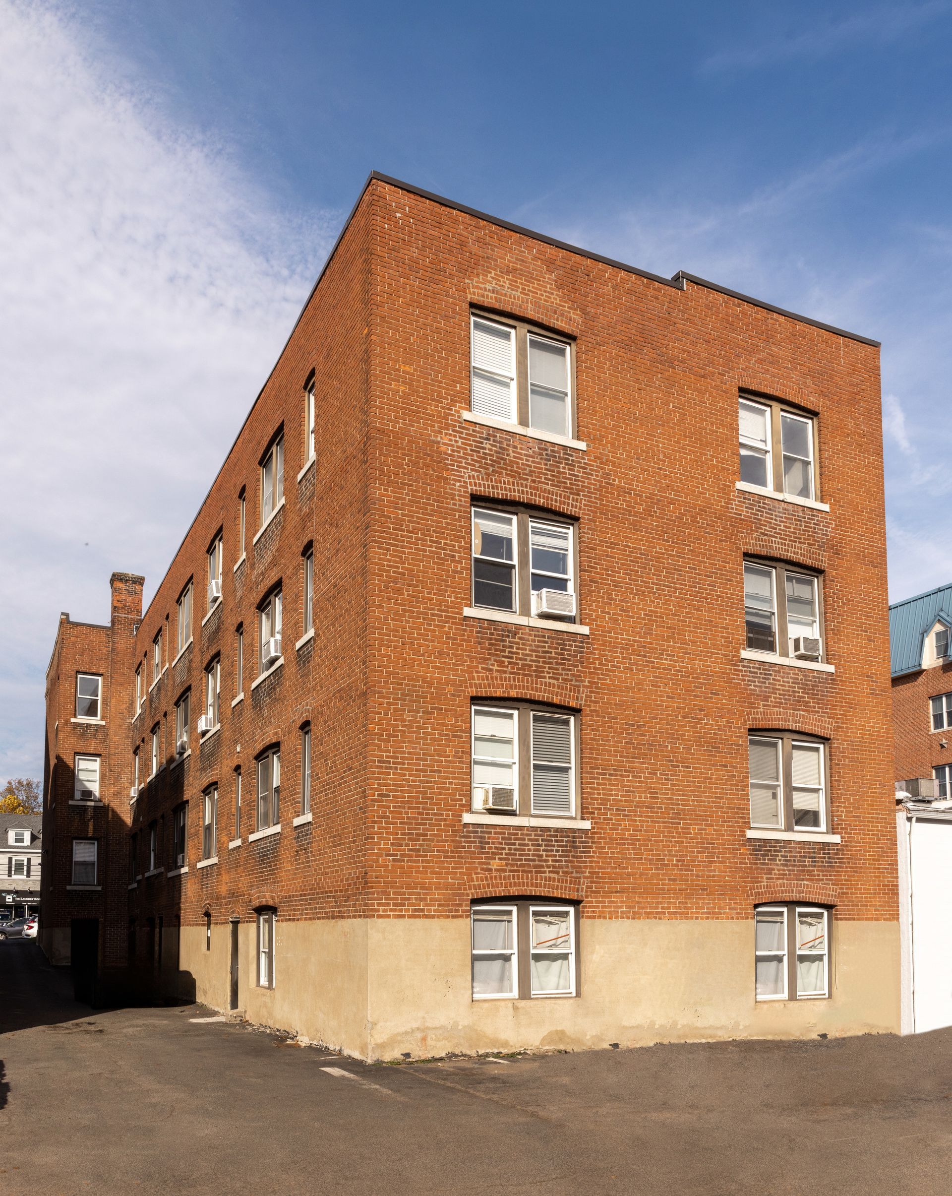 Red brick apartment building against a blue sky.
