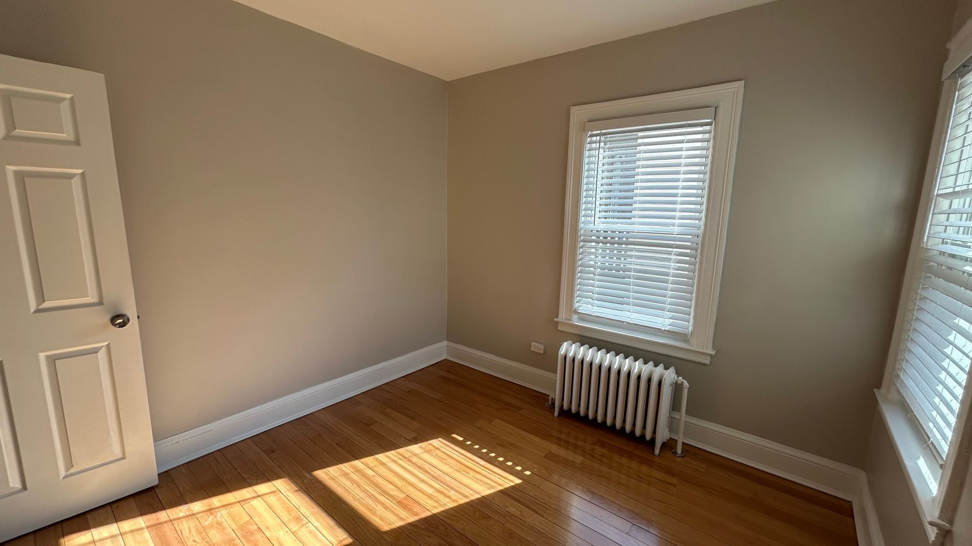 Bedroom photo of a vintage apartment with wood floors and bright natural light