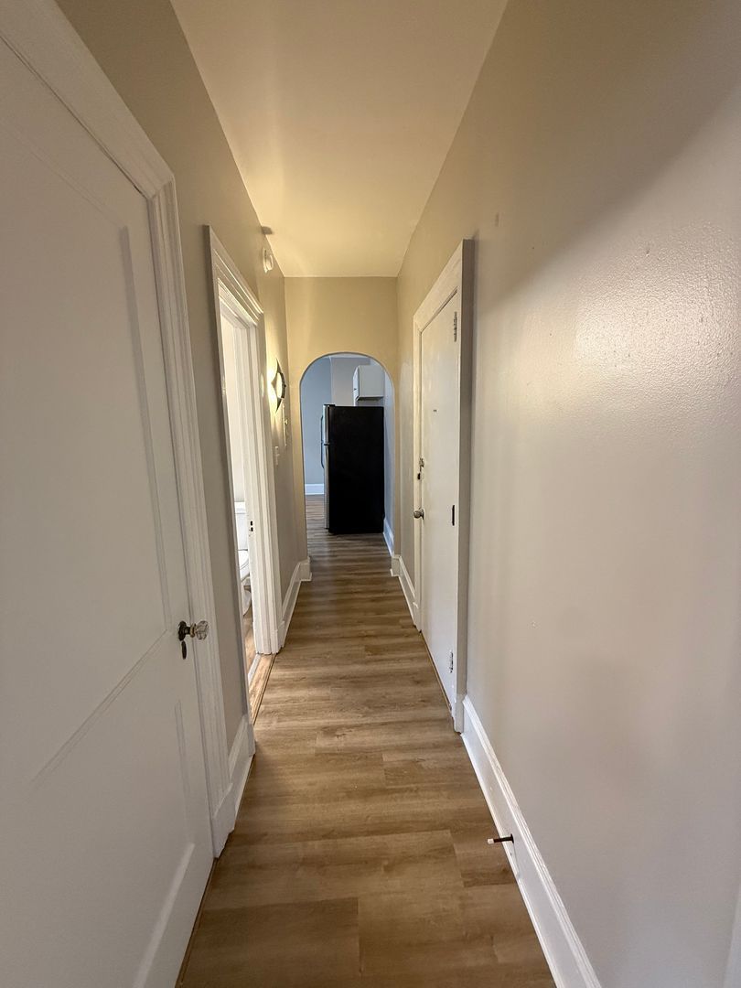 Hallway with arched doorway and white doors
