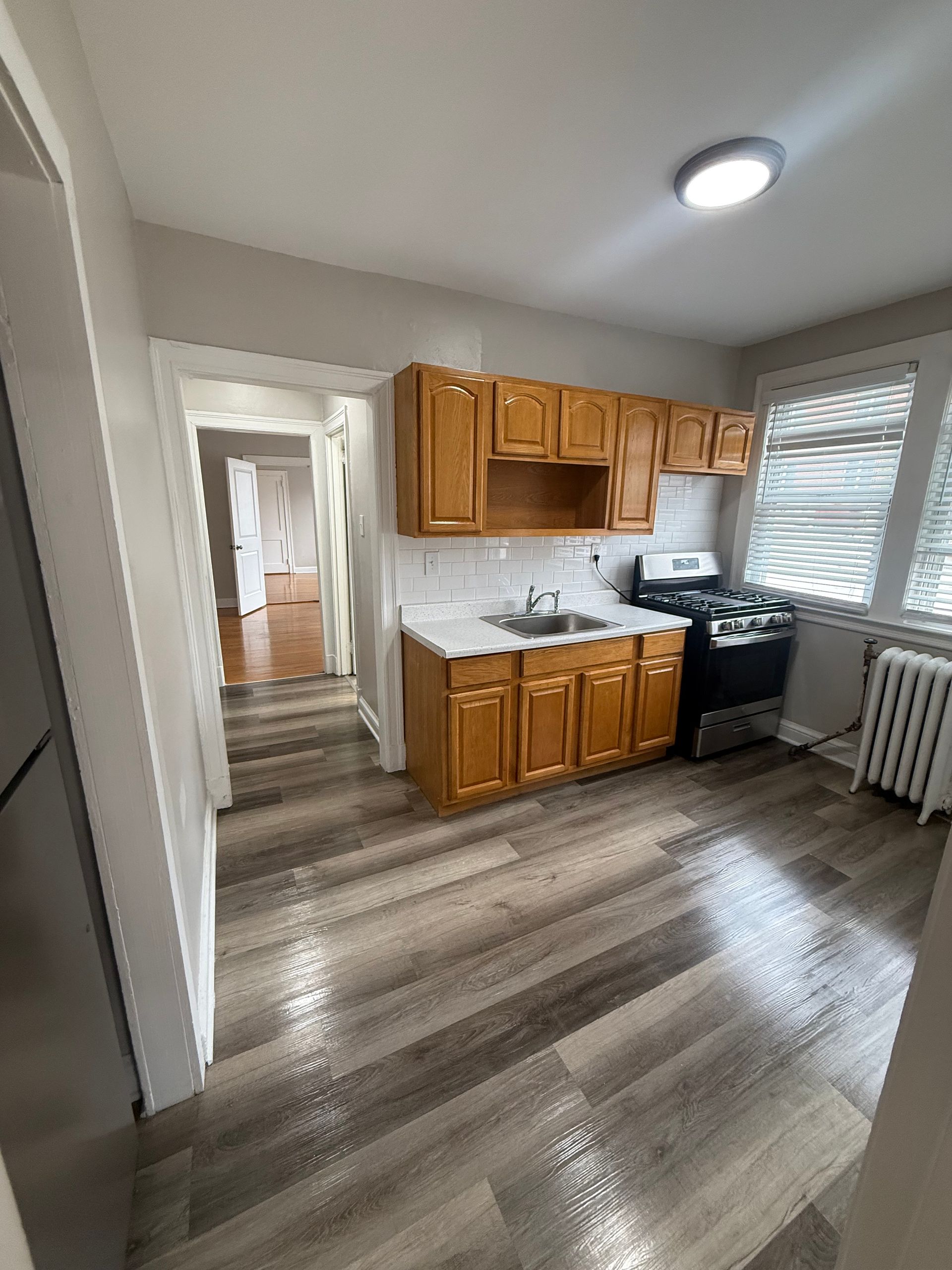 Renovated kitchen with wood cabinets, flooring, and stainless steel appliances