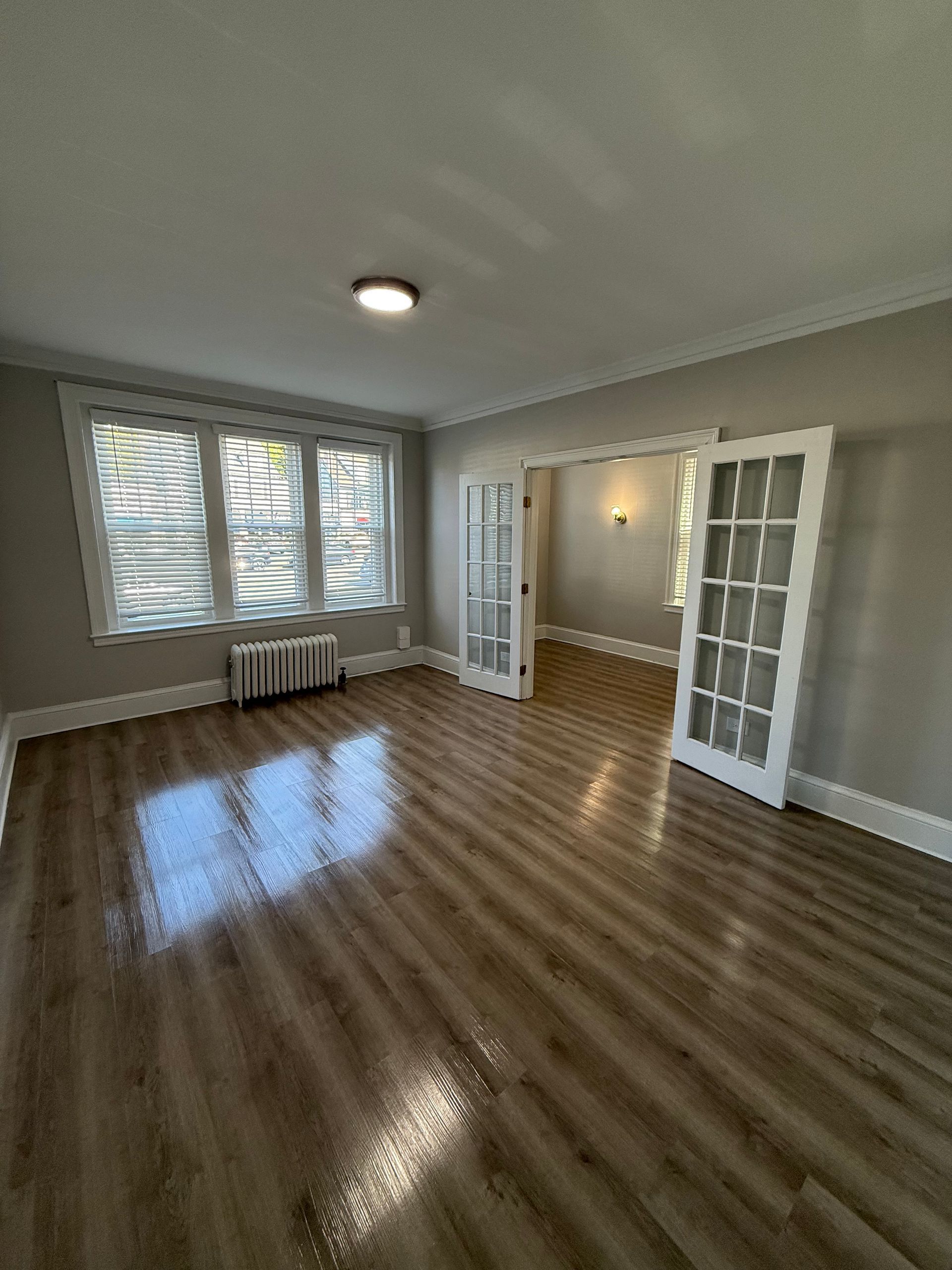 living room photo of a vintage apartment with wood floors and glass pane doors