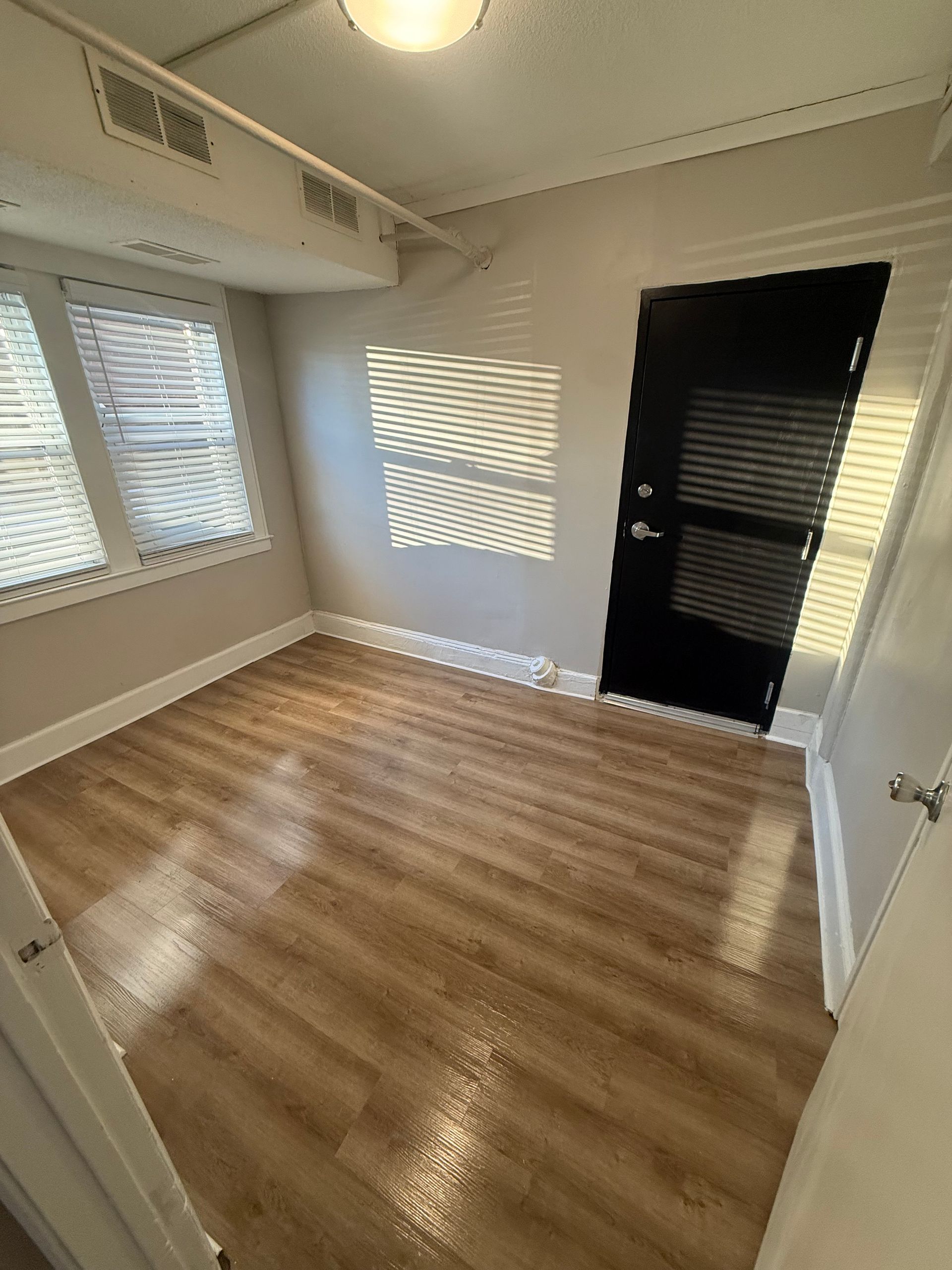 Bright living room with windows, and shadows of light through the blinds