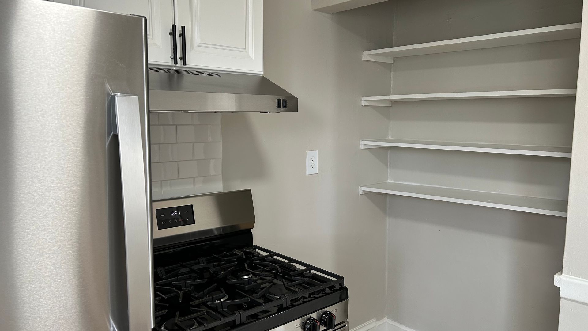 Renovated kitchen with white cabinets  and stainless steel appliances