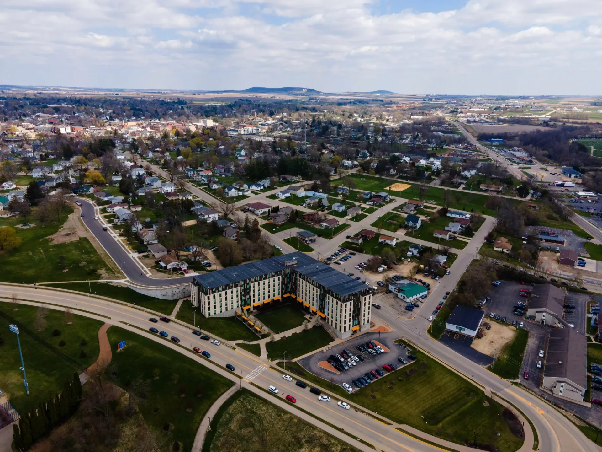 An aerial view of a city with a large building in the middle of it.