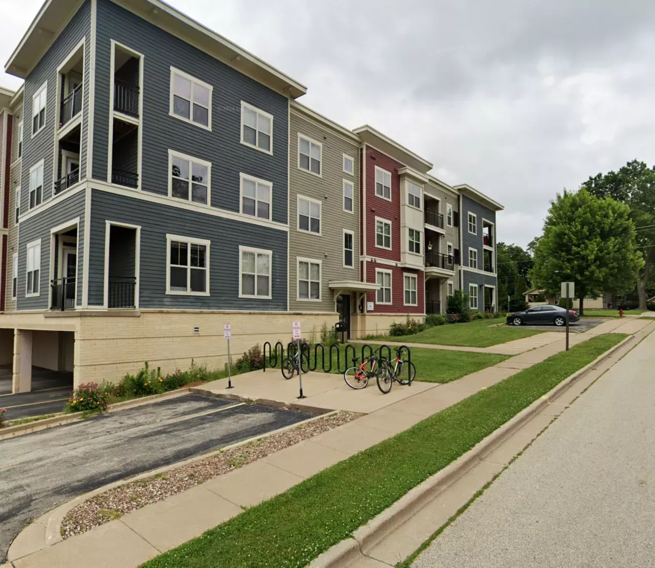 A large apartment building with a bike rack in front of it
