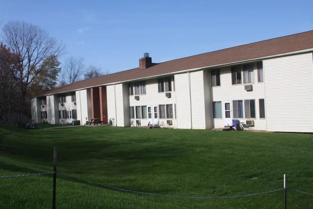 A large white apartment building with a brown roof