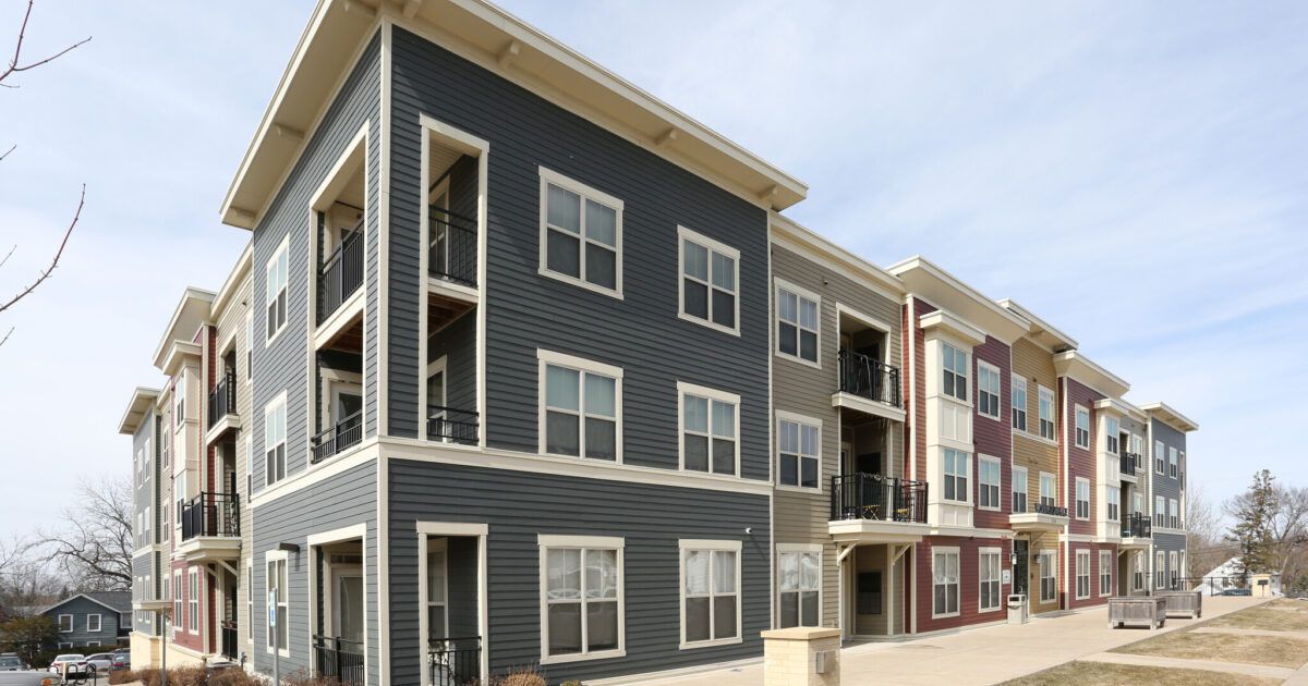 A large apartment building with a lot of windows and balconies.