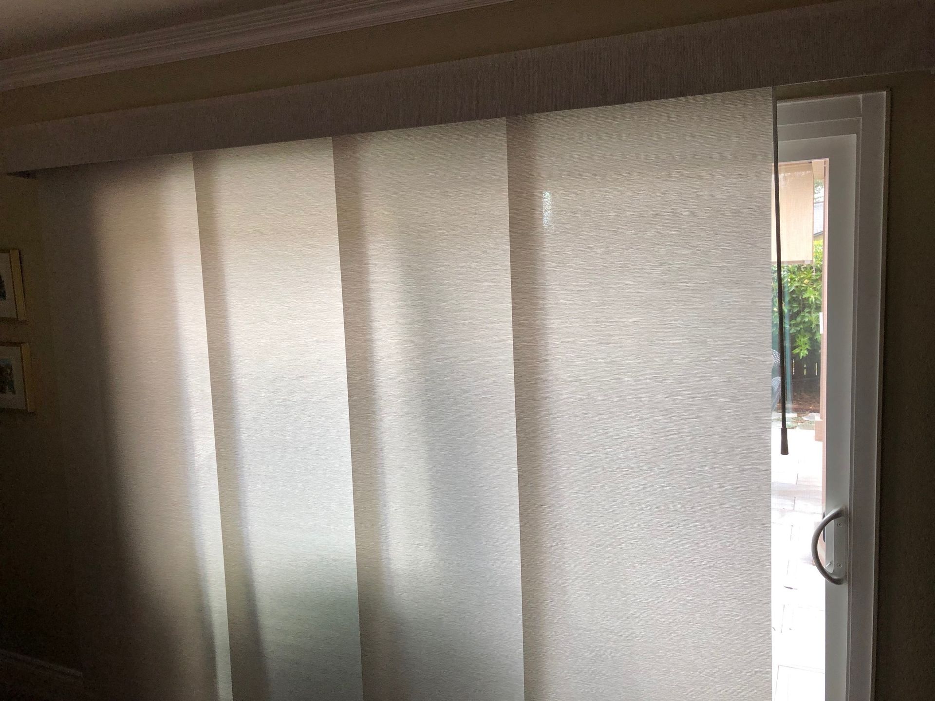 A sliding glass door with a white blind on it.