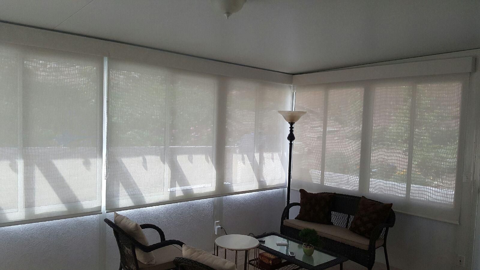 A living room with a couch , chairs , a table and a lamp.