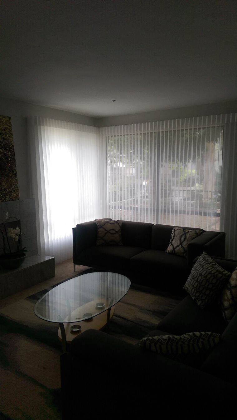 A living room with a couch , coffee table , and sliding glass doors.