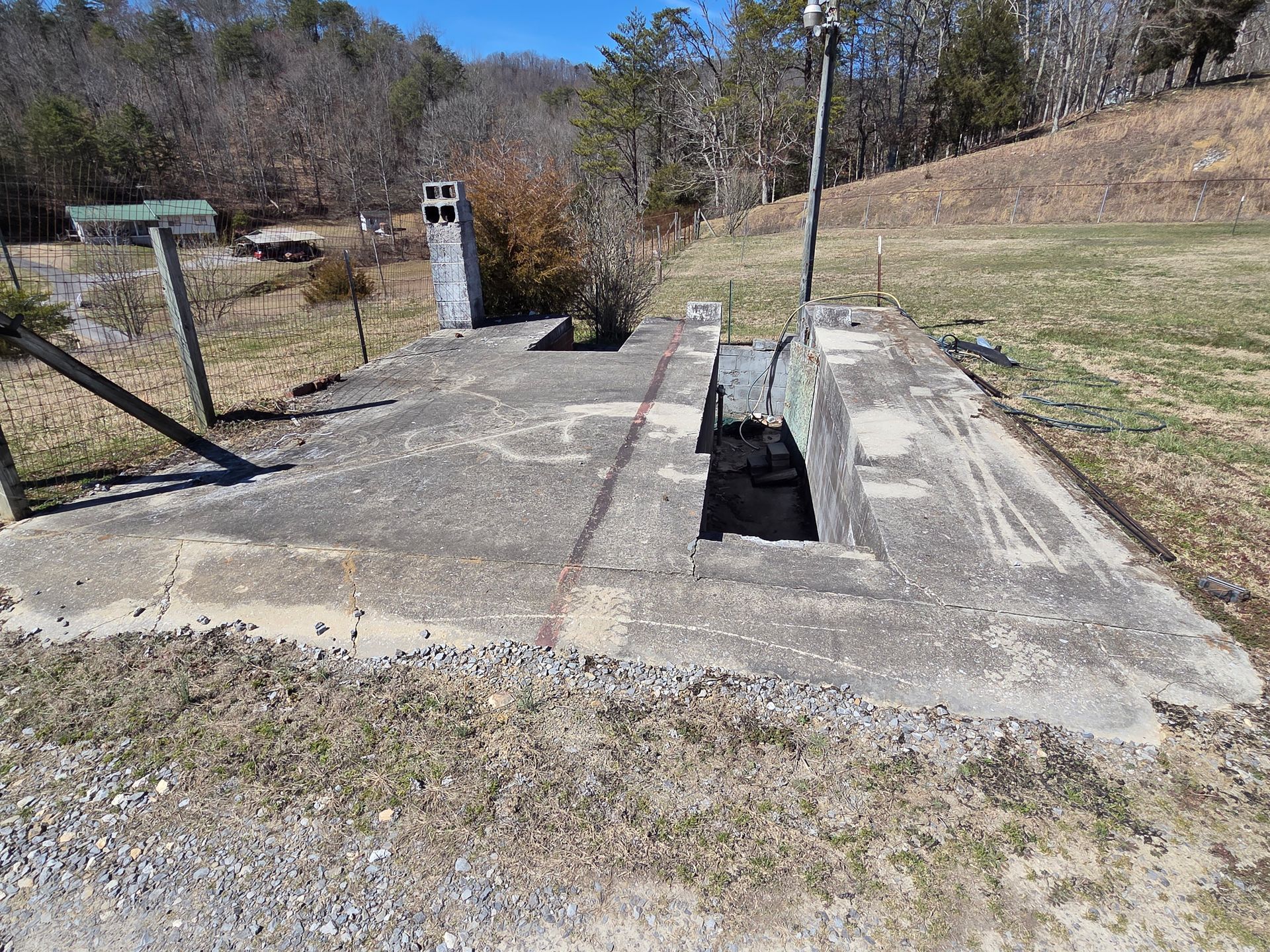 There is a hole in the ground in the middle of a field.