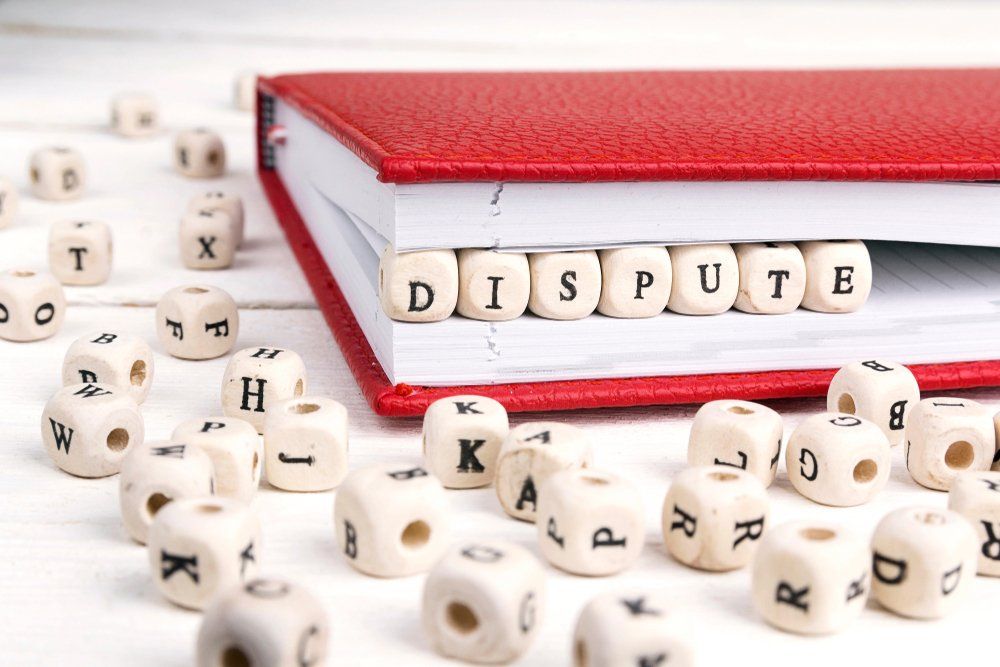 Word Dispute Written In Wooden Blocks In Red Notebook — Criminal Law Firm In Brisbane, QLD