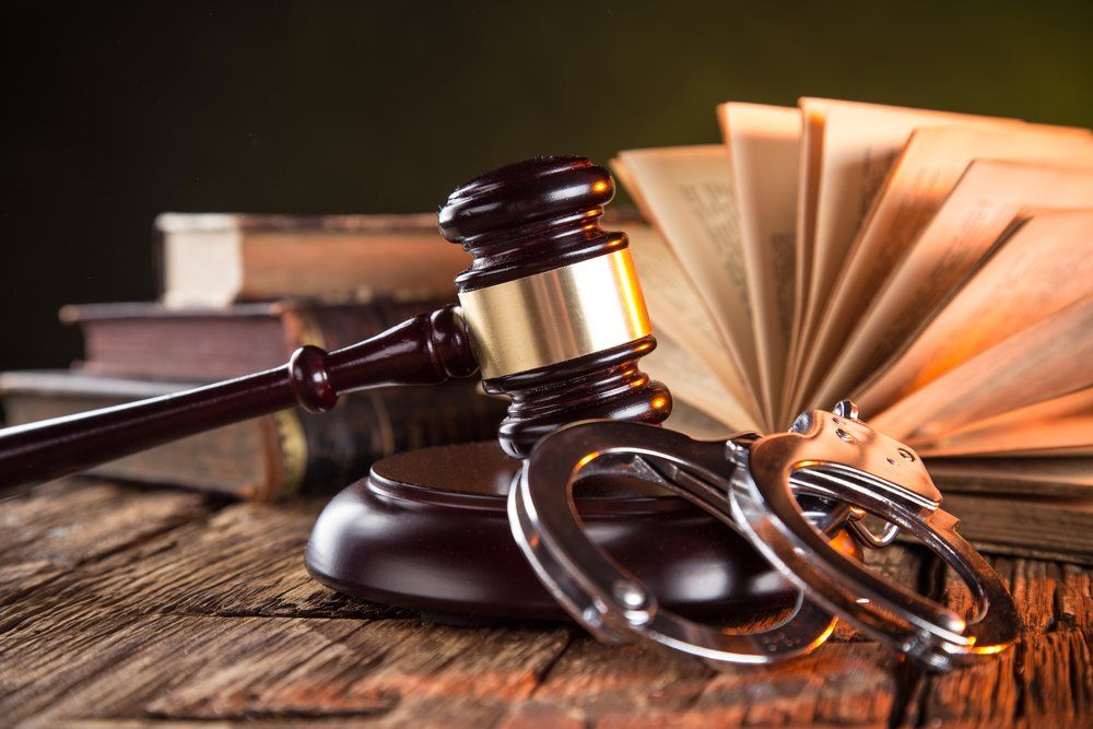 Wooden Gavel, Handcuffs And Books On Wooden Table — Criminal Law Firm In Brisbane, QLD