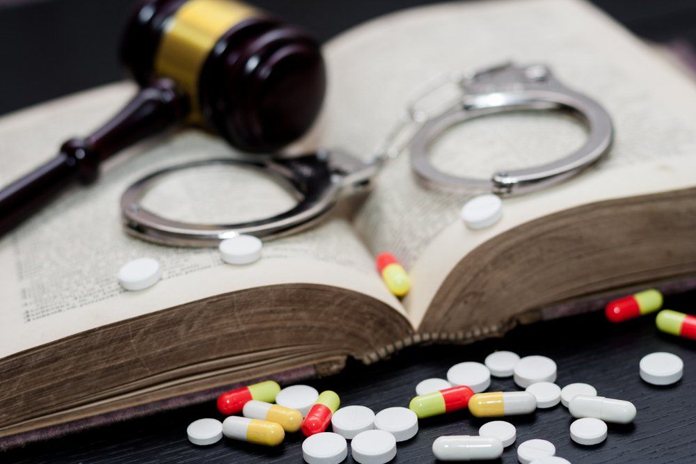 Judge's Gavel With Handcuffs And Drugs On An Open Book — Criminal Law Firm In Brisbane, QLD