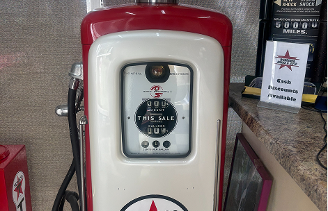 A vintage red and white Texaco gasoline pump featuring a central circular meter display, situated on a counter. | Waggener Brake and Auto Repair