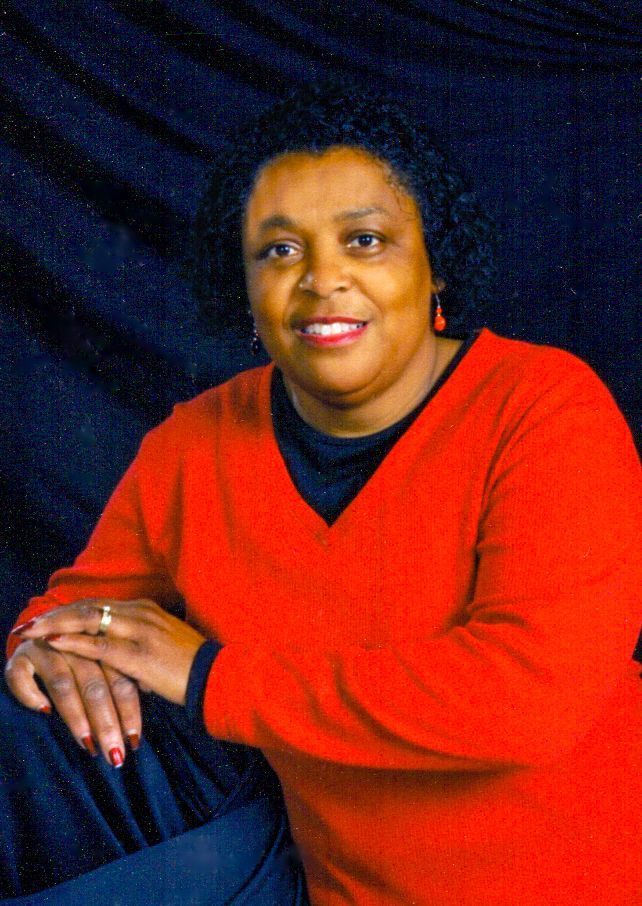 A woman in a red sweater is posing for a picture