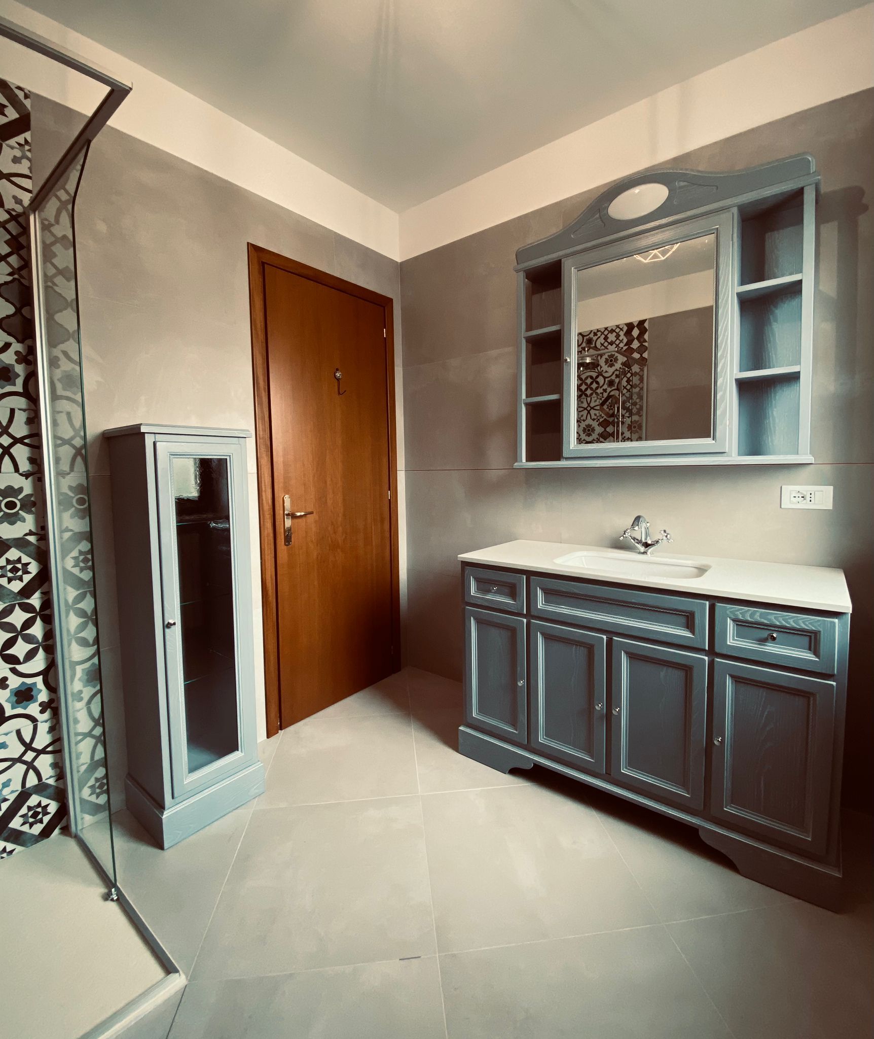 Un bagno con lavandino, specchio e armadietti