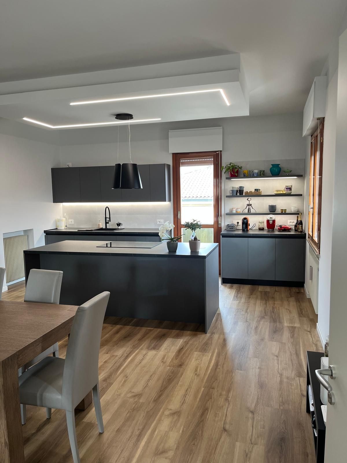 Una cucina con una grande isola, un tavolo e delle sedie.