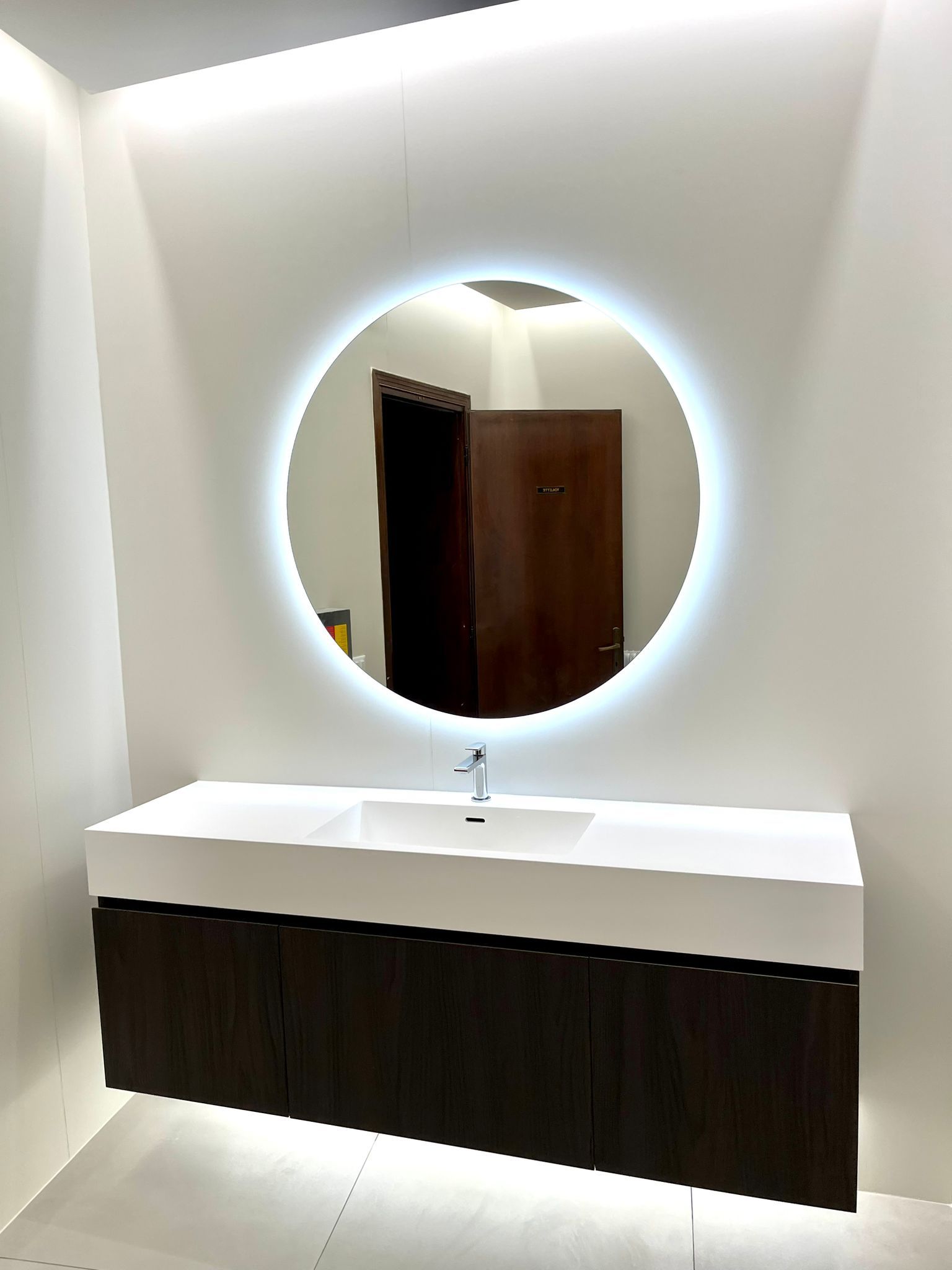 Un bagno con uno specchio rotondo e un lavandino