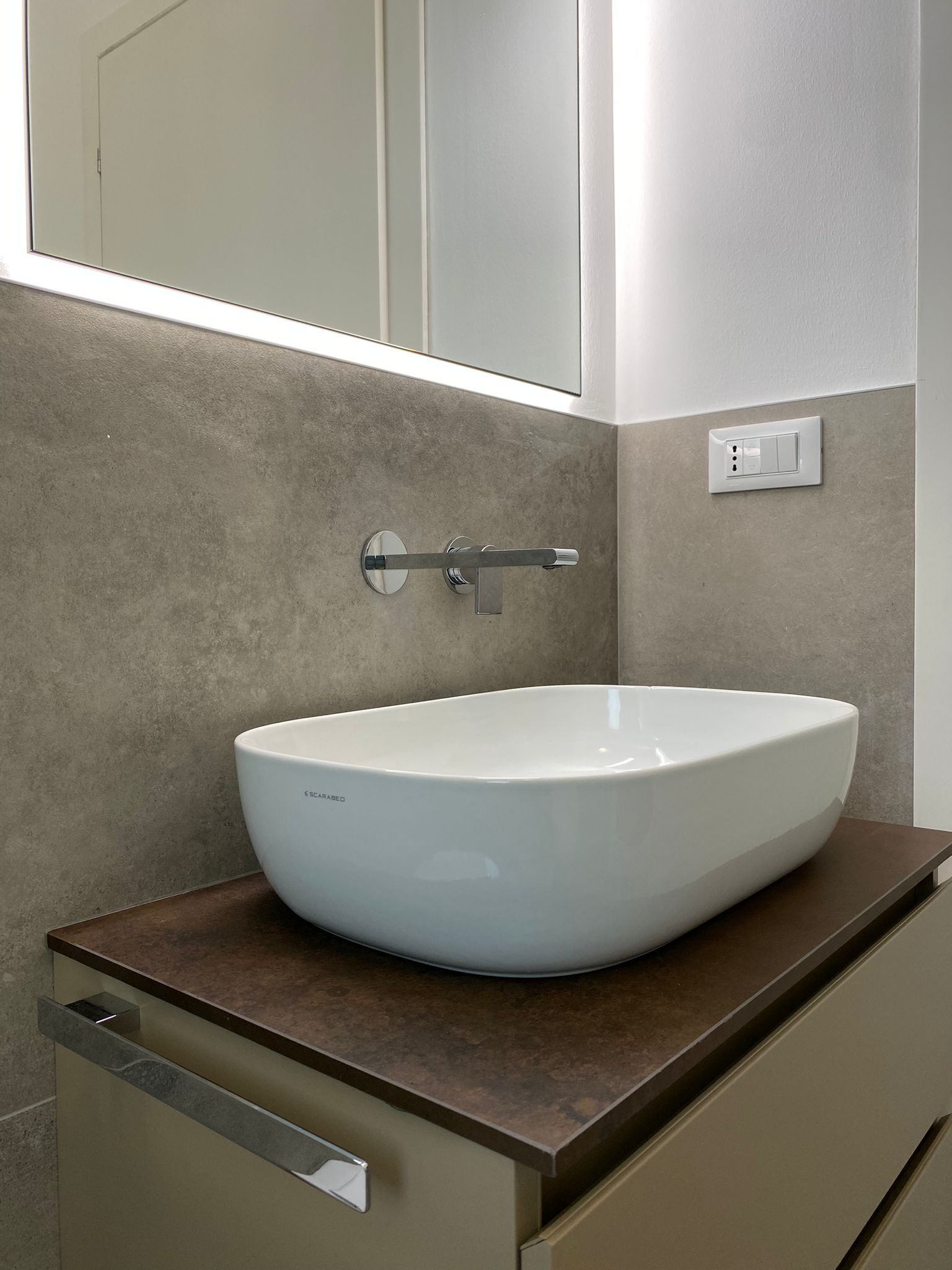 Un lavandino del bagno è appoggiato su un ripiano di legno.