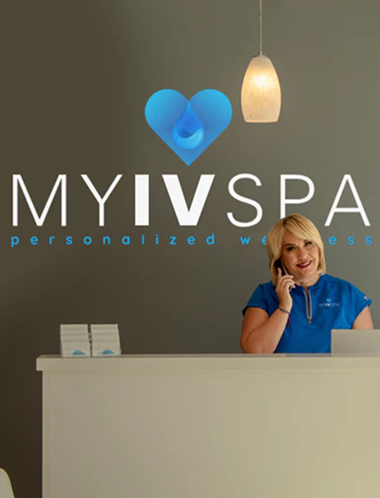 A woman at a spa reception desk, talking on the phone. 