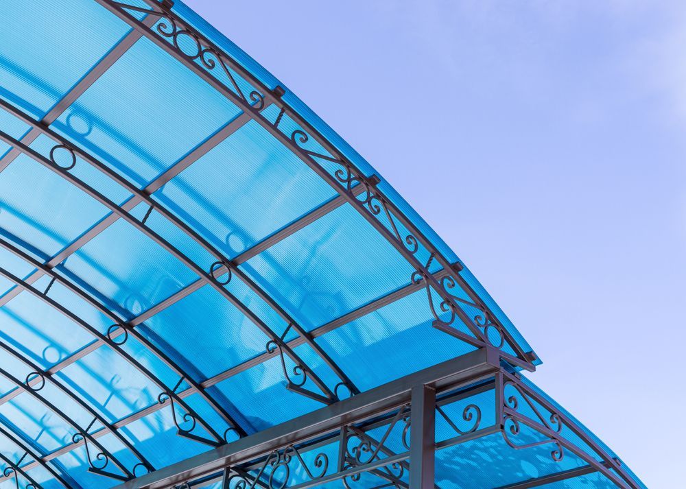 A Blue Canopy With A Wrought Iron Frame Is Against A Blue Sky — GGS Alice Glass & Aluminium In Ciccone, NT