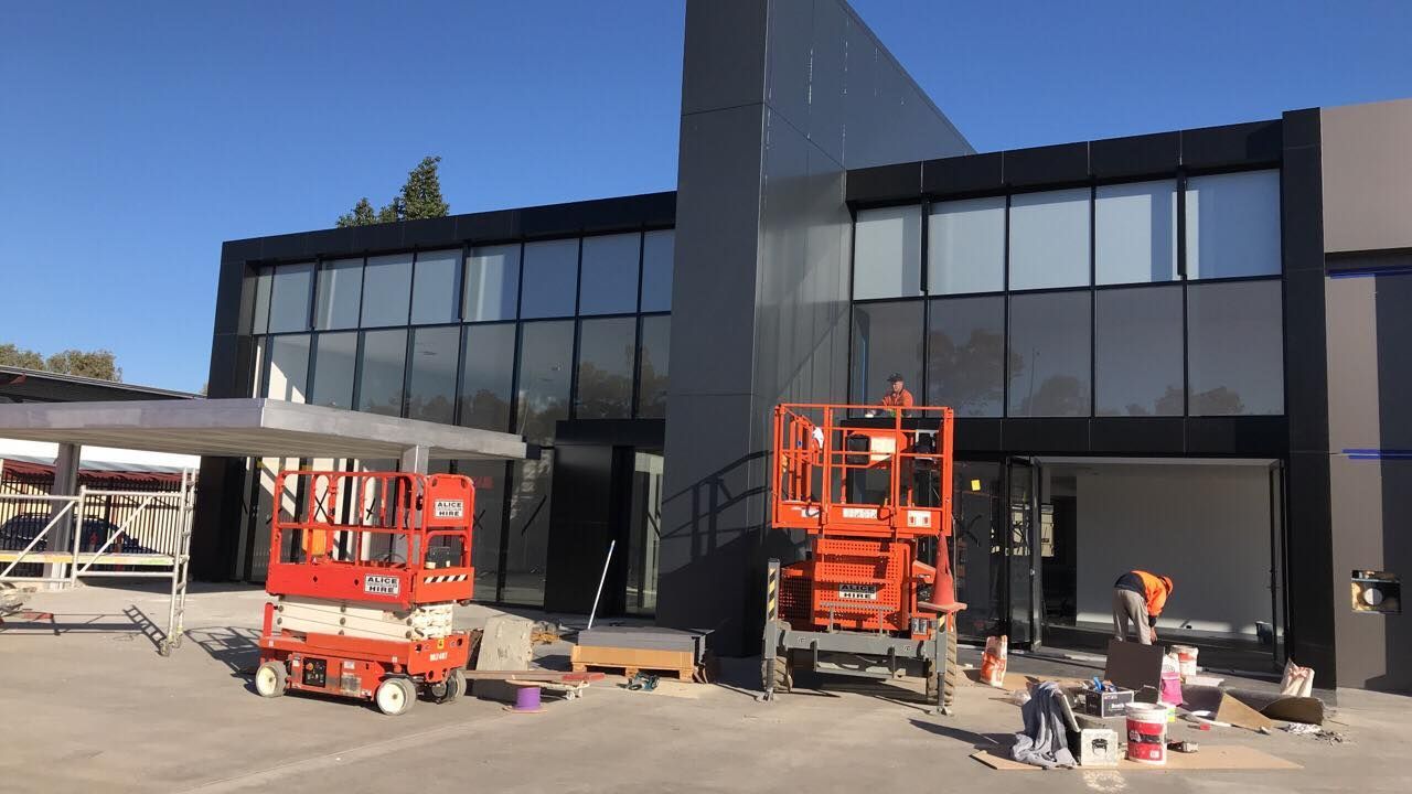 A Large Building With A Lot Of Windows Is Being Painted — GGS Alice Glass & Aluminium In Ciccone, NT