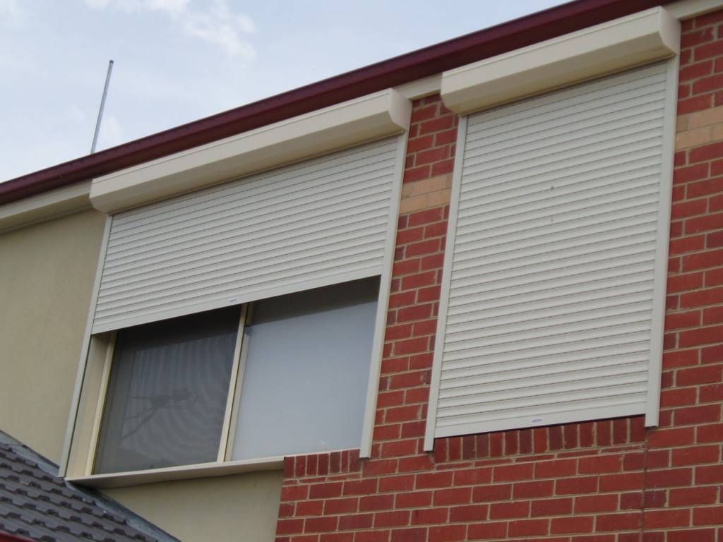 A Brick Building With White Roller Shutters On The Windows — GGS Alice Glass & Aluminium In Ciccone, NT