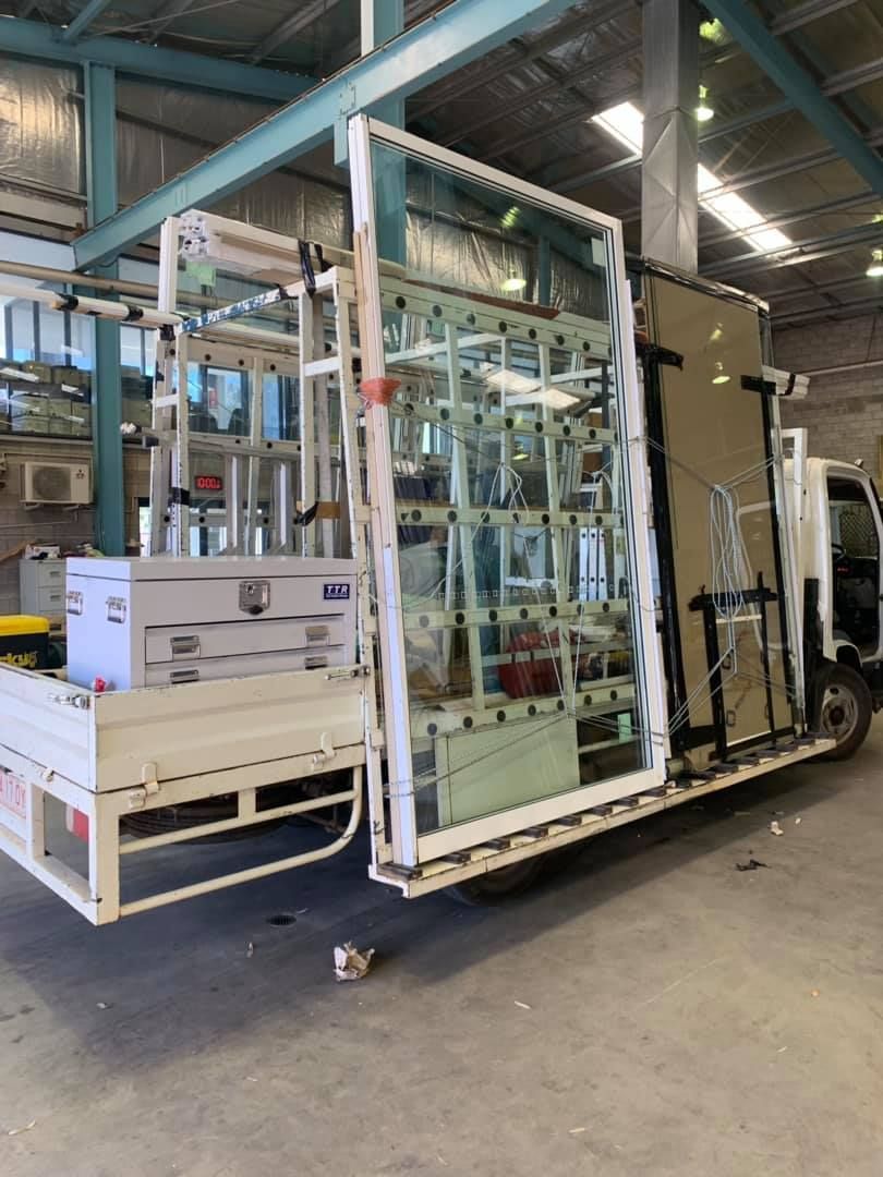A Truck With A Lot Of Glass On The Back Is Parked In A Garage — GGS Alice Glass & Aluminium In Ciccone, NT