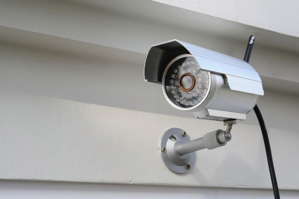 A security camera is mounted on the side of a building.