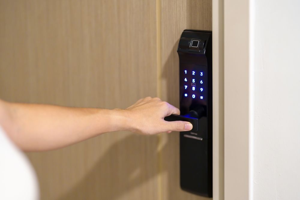 A person is using a fingerprint lock to open a door.