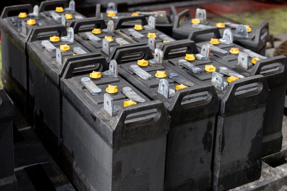 A bunch of batteries are stacked on top of each other on a table.