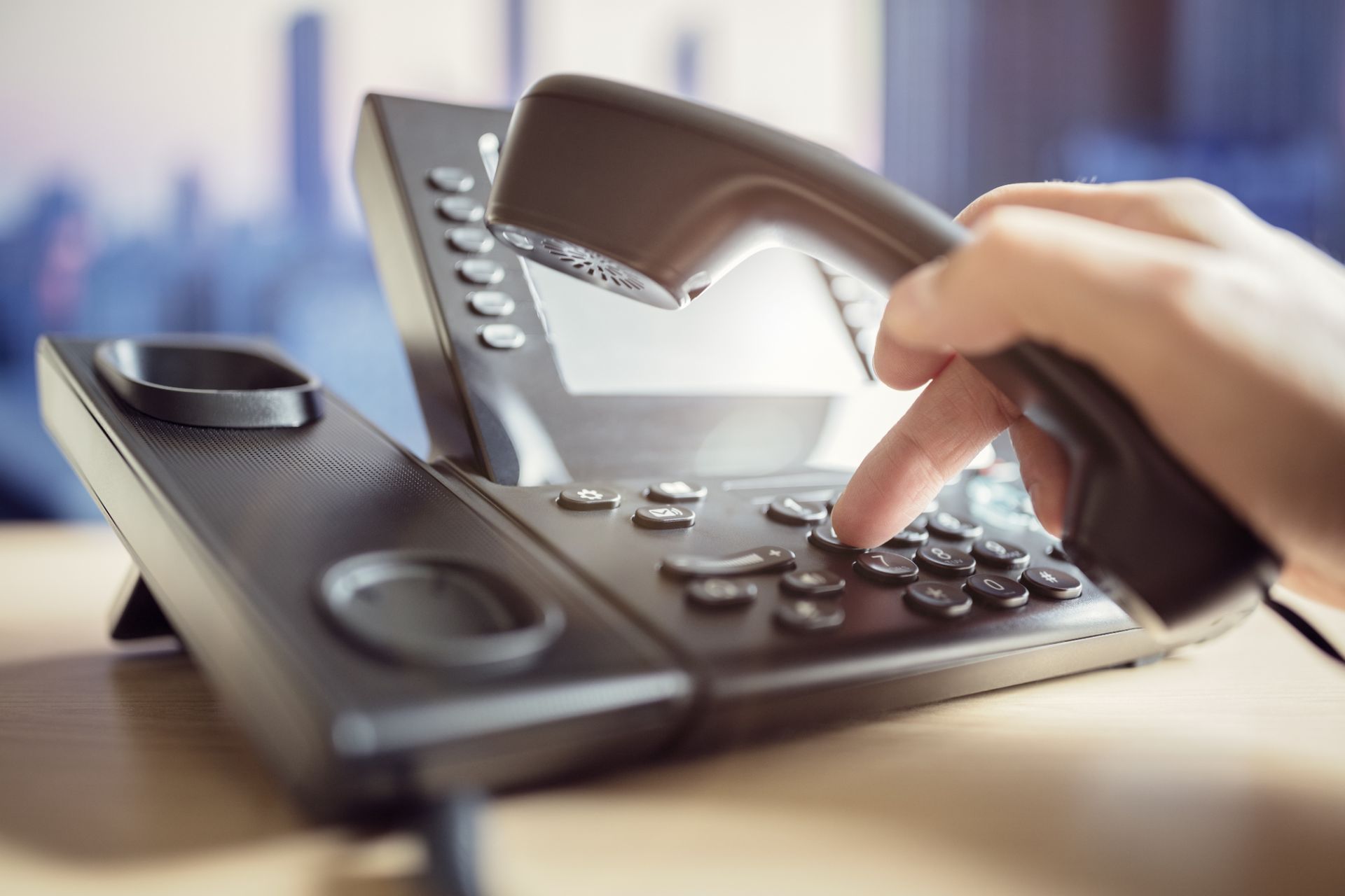 A person is pressing a button on a telephone.