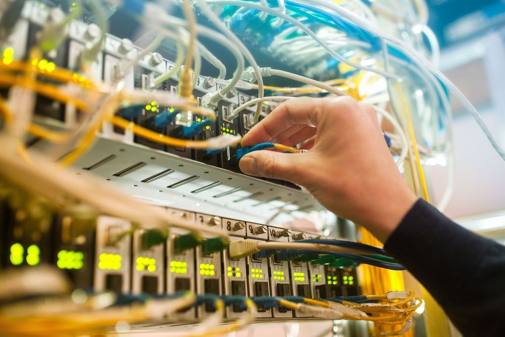 A person is working on a server in a data center.