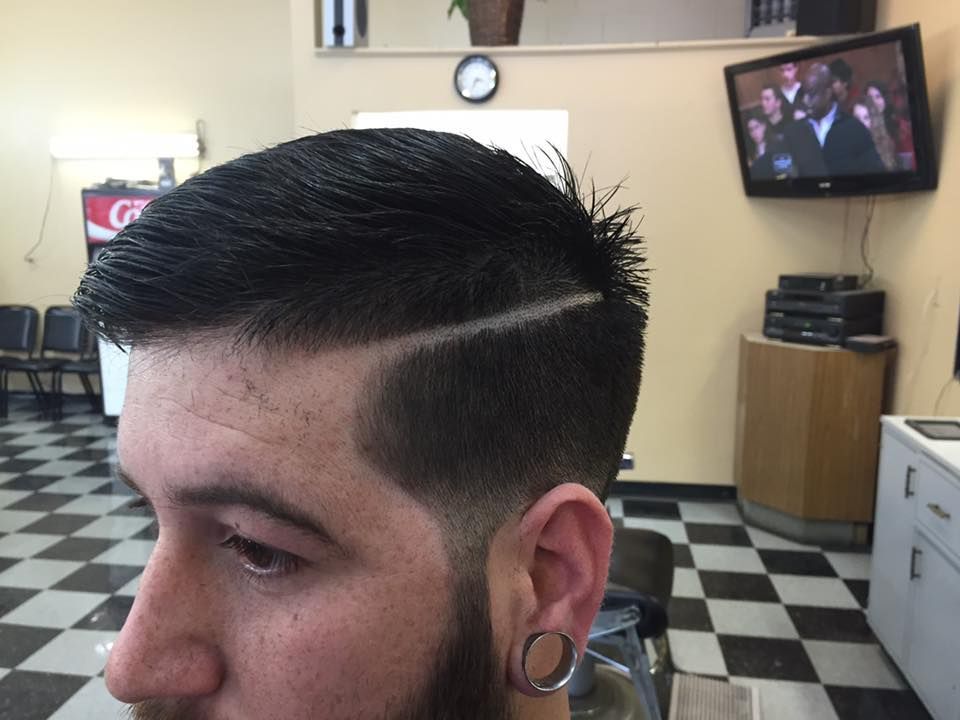 A man is getting his hair cut at a barber shop