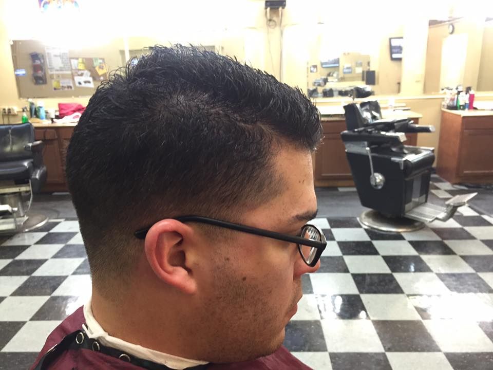 A man is getting his hair cut at a barber shop