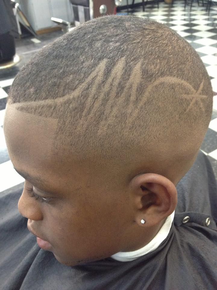 A young boy is getting his hair cut at a barber shop