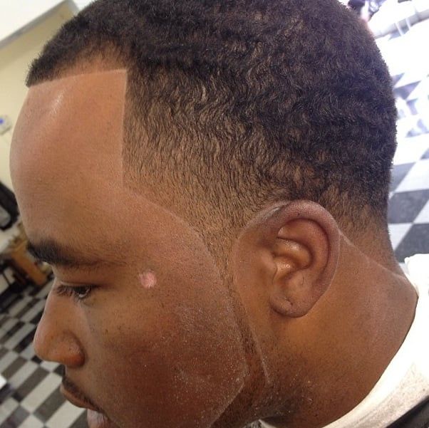 A man is getting his hair cut at a barber shop