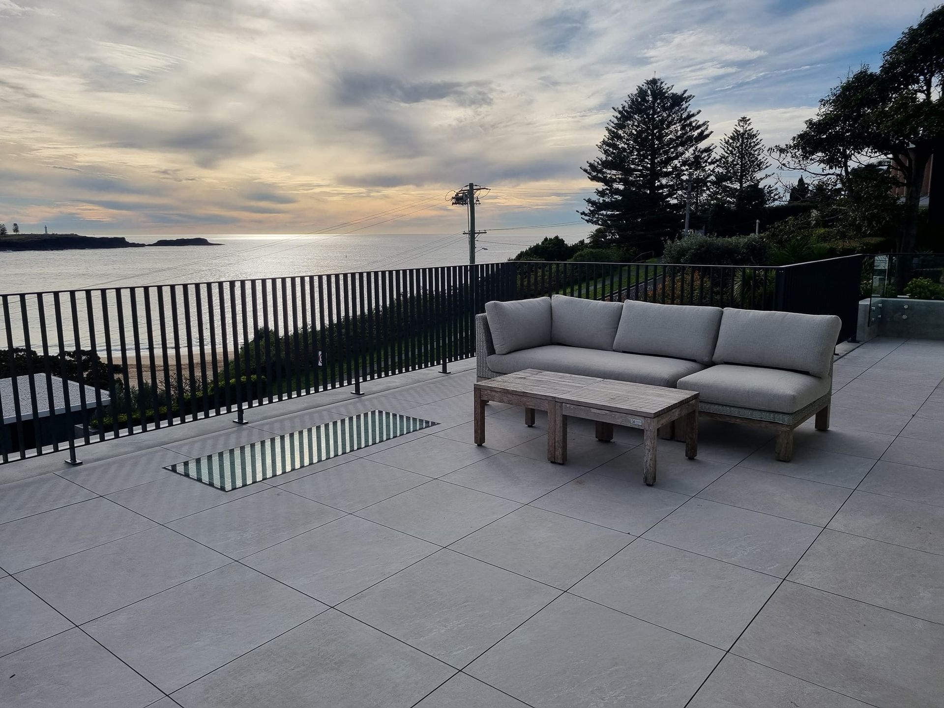 A Patio With a Couch and a Table Overlooking the Ocean — D & T Balustrade Systems In Unanderra, NSW
