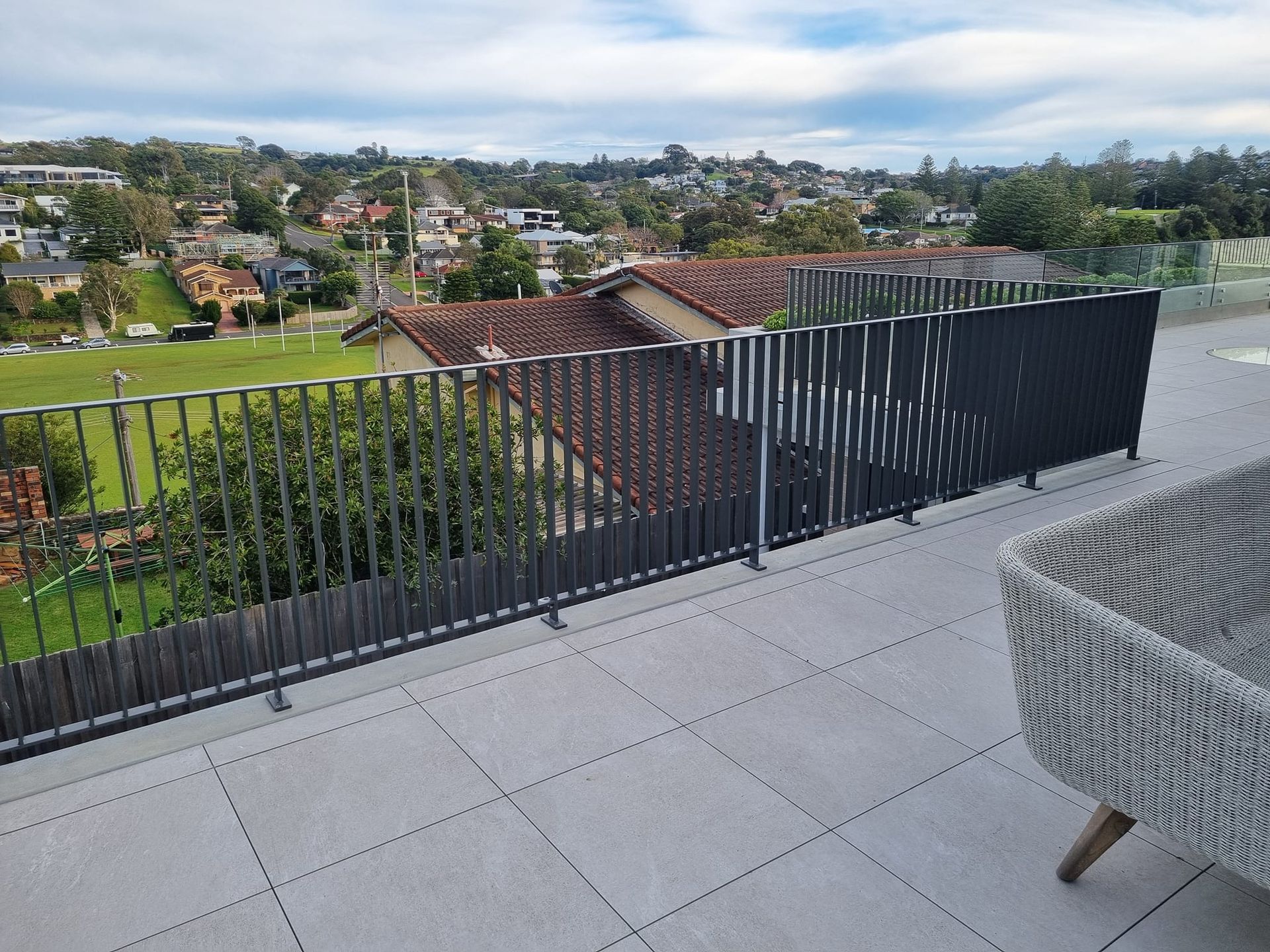 Rooftop With Dark Balustrades Overlooking A Residential Neighborhood
